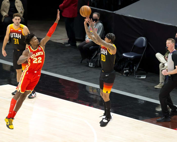 Jordan Clarkson (00) shoots a three-pointer over Cam Reddish (22)